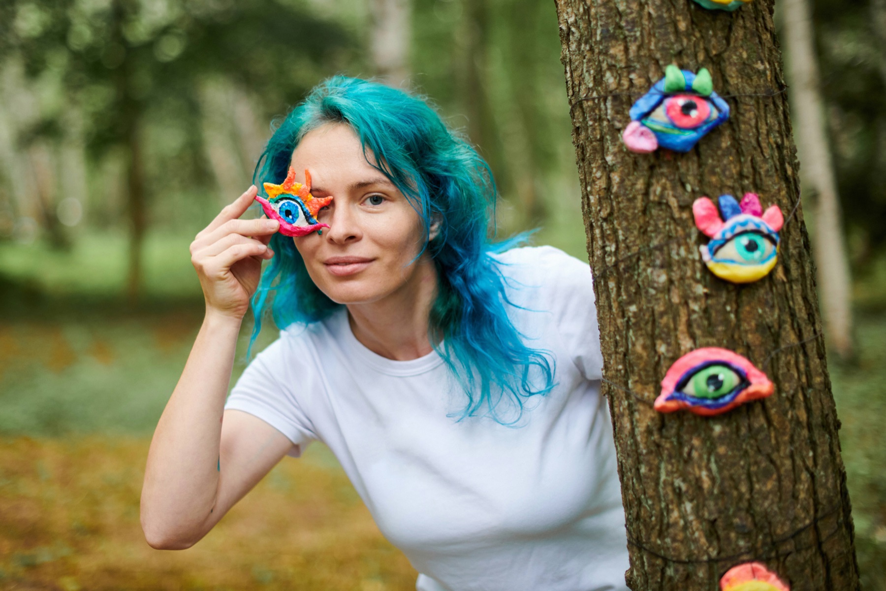 Participant holding a colourful polymer eye artwork